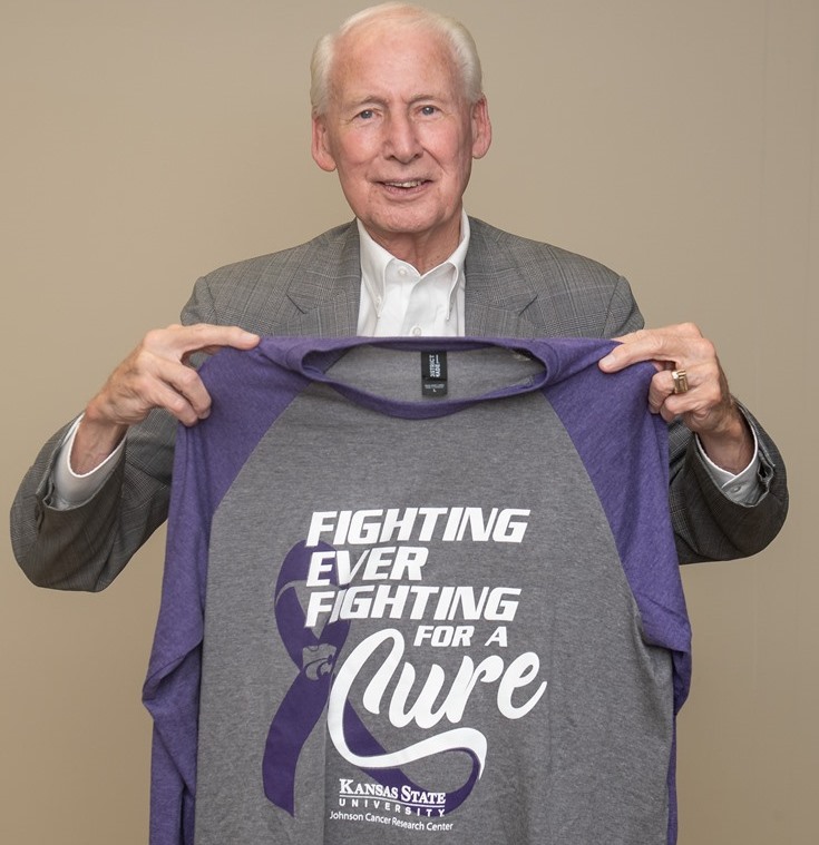 Coach Bill Snyder holding 2021 K-State Fighting for a Cure shirt
