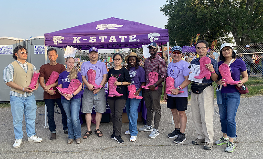 students and faculty standing with pink boots at the rodeo to collect money 